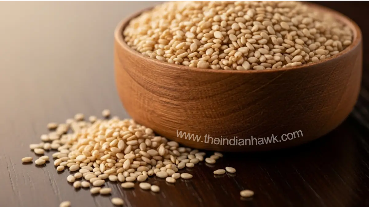 A close-up shot of a small wooden bowl filled with sesame seeds, with some scattered on a dark wooden surface, symbolizing the importance of sesame in Makar Sankranti rituals.